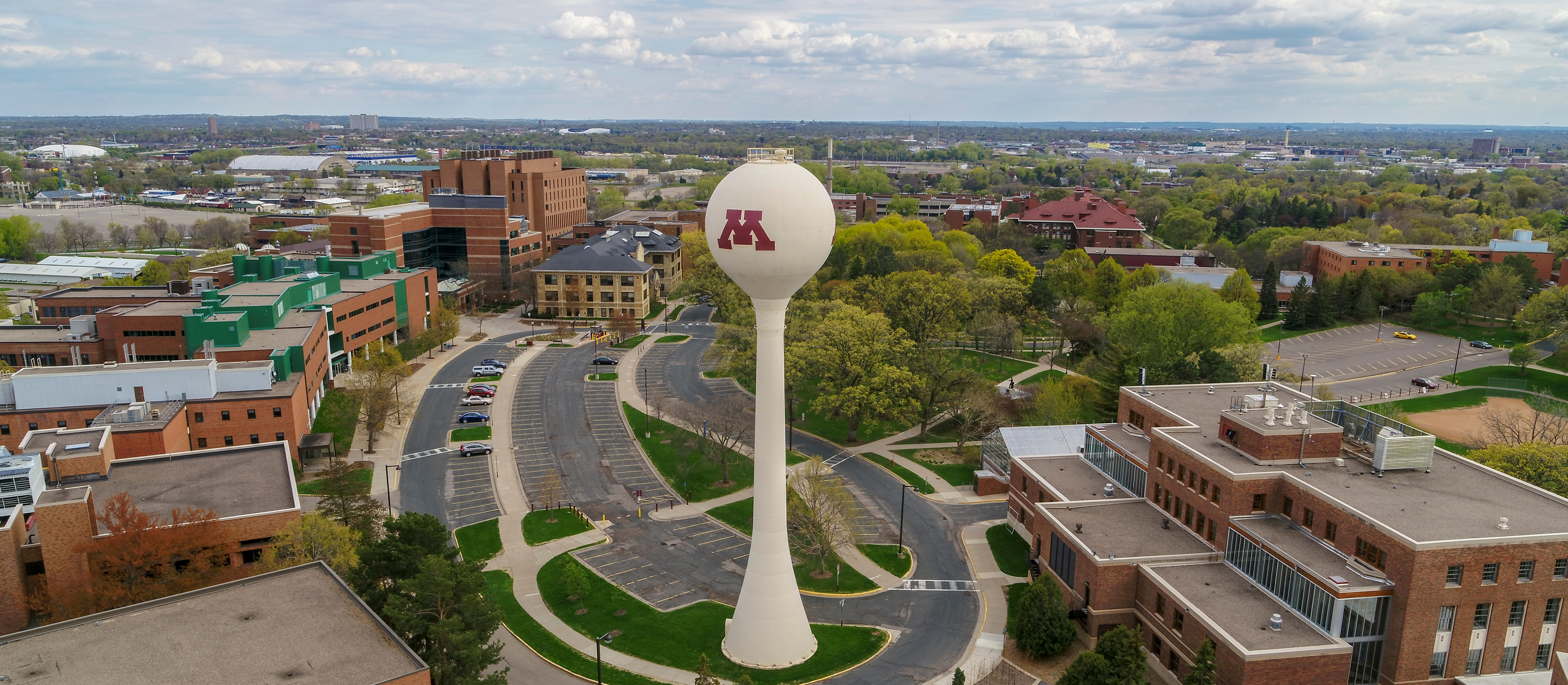 An aerial view of buildings surrounding a water tower with a maroon "M" on it